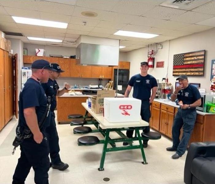 Firefighters standing around table of food donated by SERVPRO of Corpus Christi East